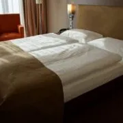 Cameră de hotel amenajată cu lenjerie de pat albă
