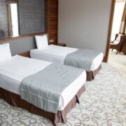 Cameră de hotel twin, cu două paturi single separate și o fereastră luminoasă