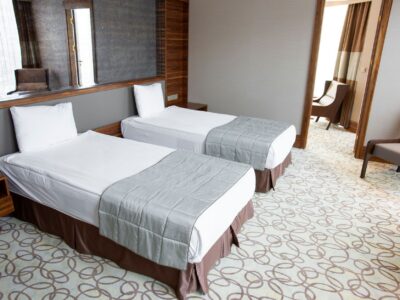 Cameră de hotel twin, cu două paturi single separate și o fereastră luminoasă