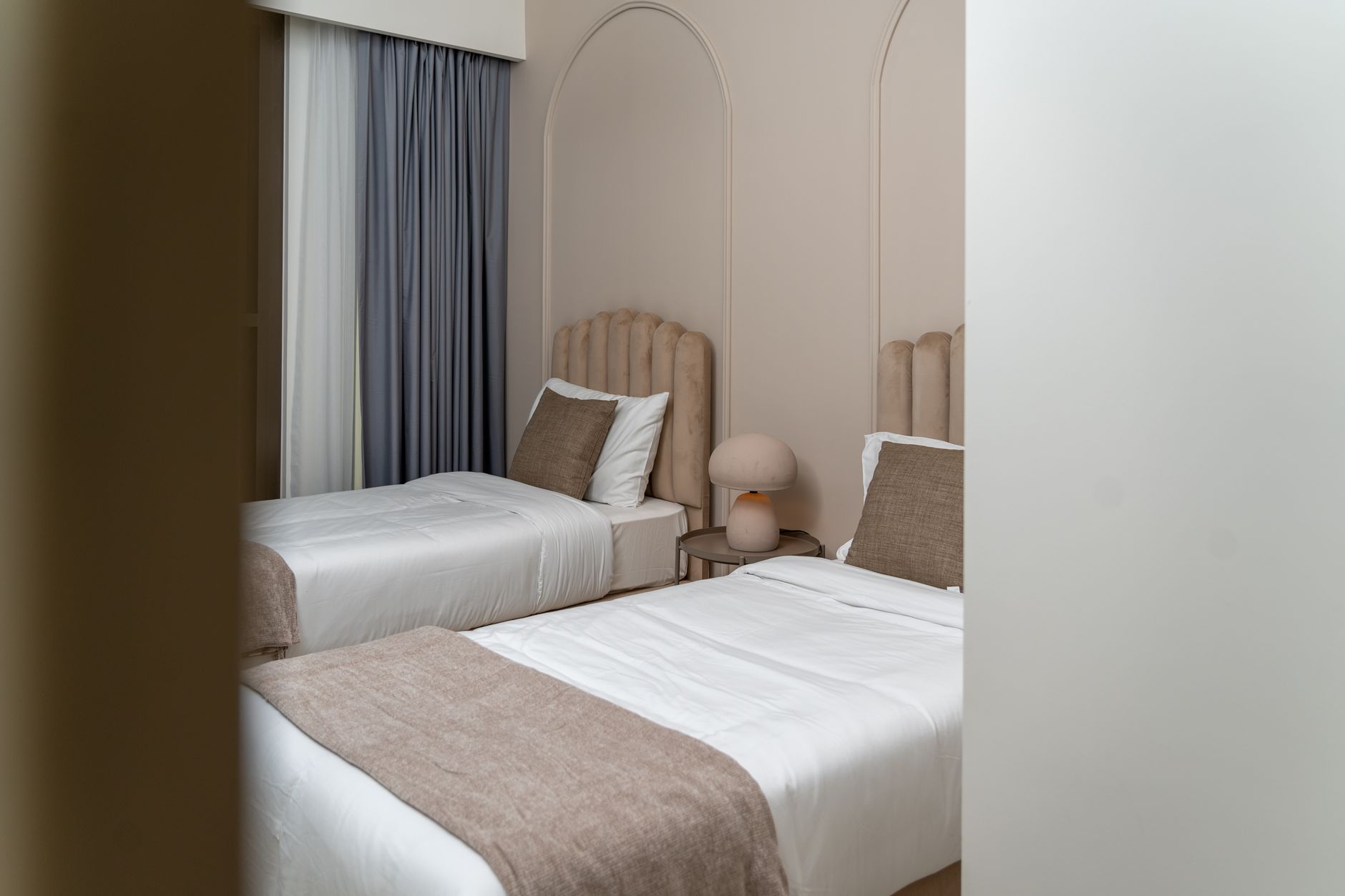 Baie de hotel adaptată, cu duș la nivelul pardoselii, bare de sprijin și scaun rabatabil