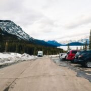 Pensiune de munte cu mașinile turiștilor parcate în curte, într-o minivacanță de weekend prelungit