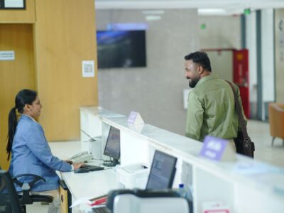 Formular de înregistrare a oaspeților pe blatul unei recepții de hotel, lângă o cheie de cameră